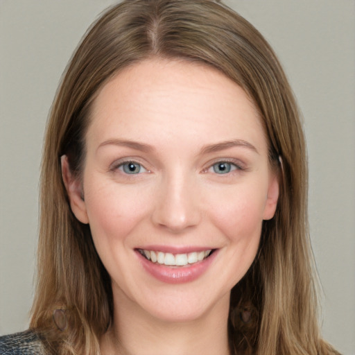 Joyful white young-adult female with long  brown hair and blue eyes