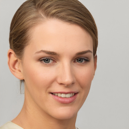 Joyful white young-adult female with short  brown hair and grey eyes