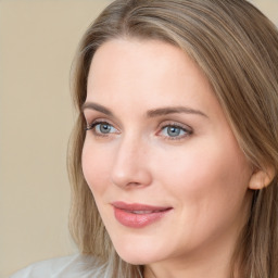 Joyful white young-adult female with long  brown hair and blue eyes