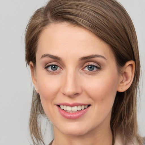 Joyful white young-adult female with medium  brown hair and grey eyes