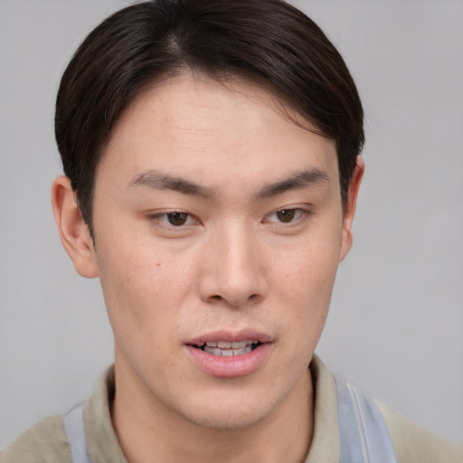 Joyful asian young-adult male with short  brown hair and brown eyes