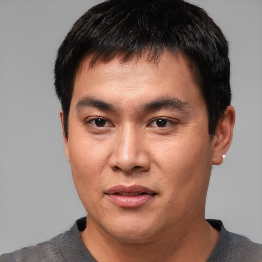 Joyful asian young-adult male with short  black hair and brown eyes