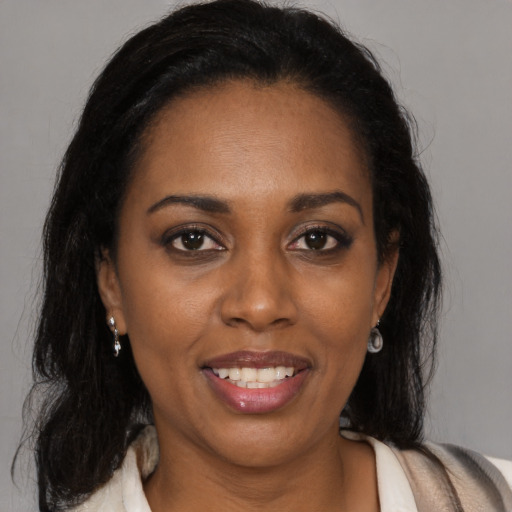 Joyful latino adult female with medium  brown hair and brown eyes