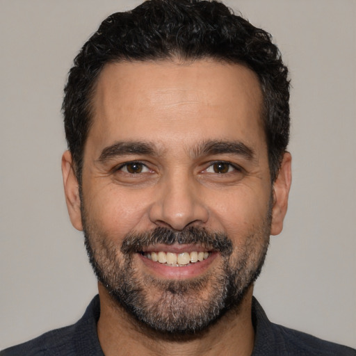 Joyful white adult male with short  black hair and brown eyes