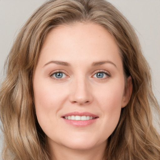 Joyful white young-adult female with long  brown hair and blue eyes