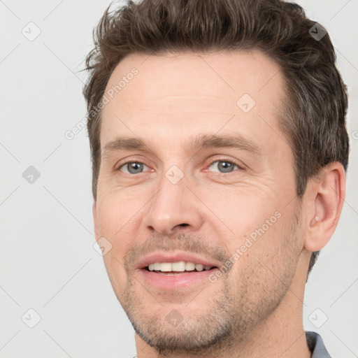 Joyful white adult male with short  brown hair and grey eyes