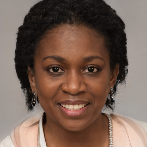 Joyful black young-adult female with short  brown hair and brown eyes