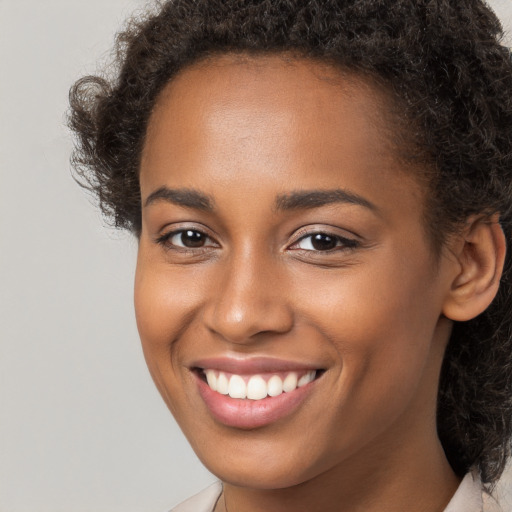 Joyful black young-adult female with medium  brown hair and brown eyes