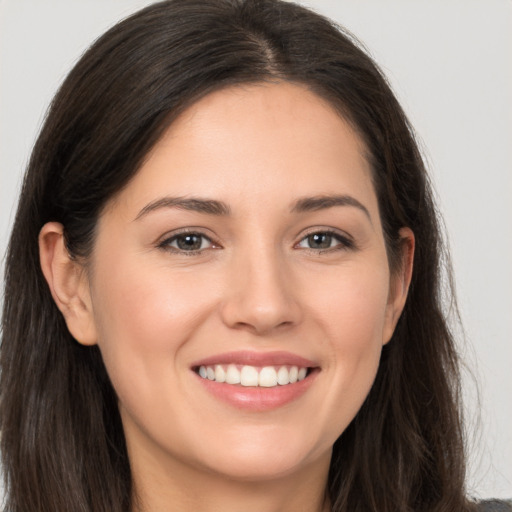 Joyful white young-adult female with long  brown hair and brown eyes