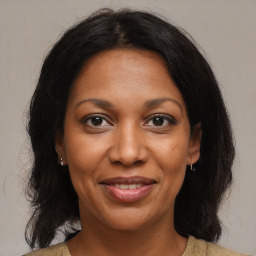 Joyful black adult female with medium  brown hair and brown eyes