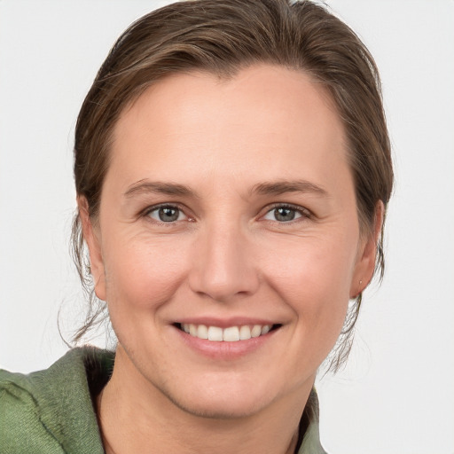 Joyful white young-adult female with medium  brown hair and grey eyes