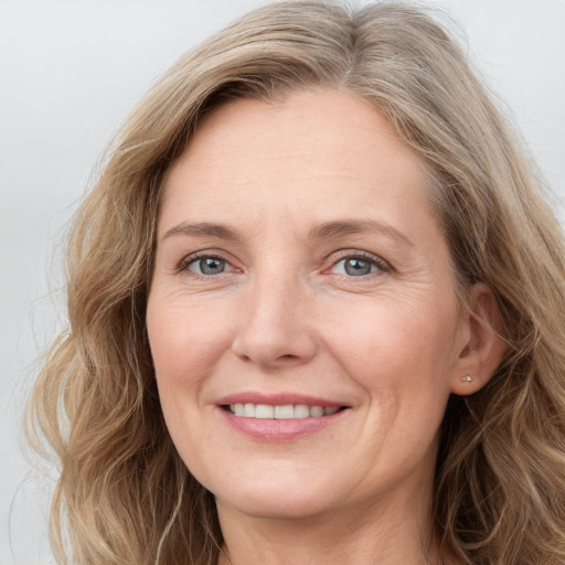 Joyful white adult female with long  brown hair and blue eyes