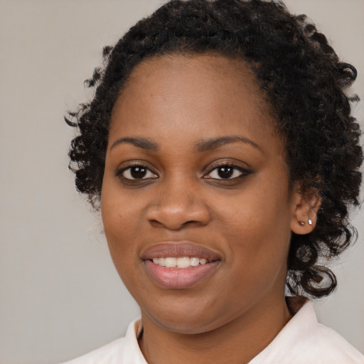 Joyful black young-adult female with medium  black hair and brown eyes