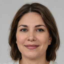 Joyful white adult female with medium  brown hair and brown eyes