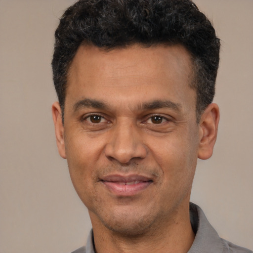 Joyful latino adult male with short  black hair and brown eyes