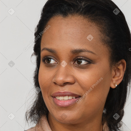 Joyful black young-adult female with long  brown hair and brown eyes