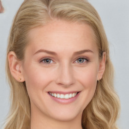 Joyful white young-adult female with long  brown hair and blue eyes