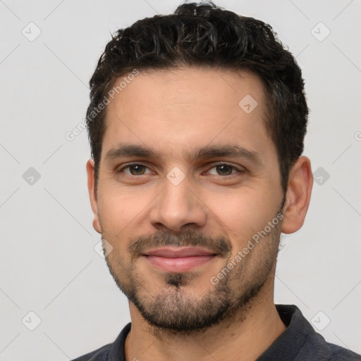 Joyful white young-adult male with short  black hair and brown eyes