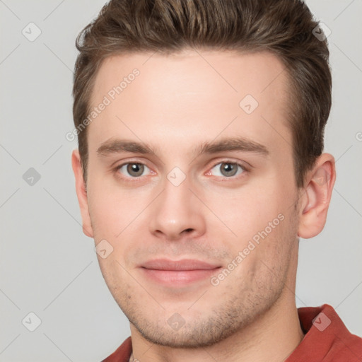 Joyful white young-adult male with short  brown hair and grey eyes