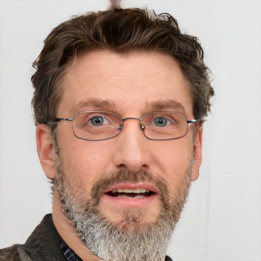 Joyful white adult male with short  brown hair and blue eyes