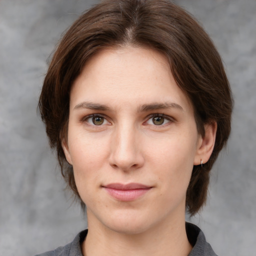 Joyful white young-adult female with medium  brown hair and grey eyes