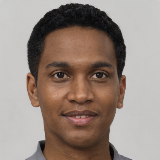 Joyful black young-adult male with short  black hair and brown eyes