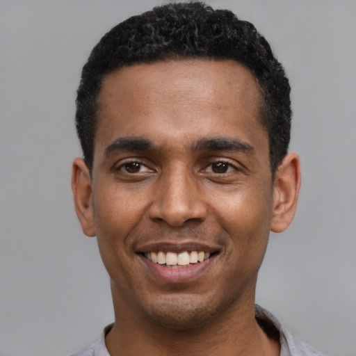 Joyful latino young-adult male with short  black hair and brown eyes
