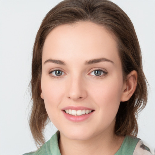 Joyful white young-adult female with medium  brown hair and green eyes