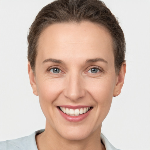 Joyful white young-adult female with short  brown hair and grey eyes