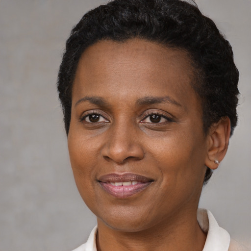Joyful black adult female with short  brown hair and brown eyes