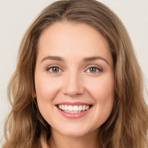 Joyful white young-adult female with long  brown hair and green eyes