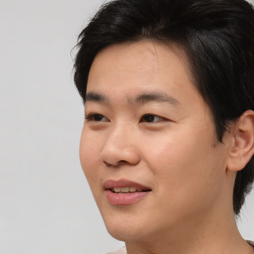 Joyful asian young-adult male with short  black hair and brown eyes