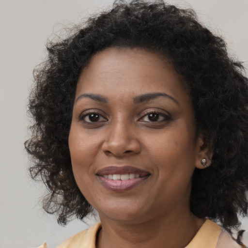 Joyful black young-adult female with medium  brown hair and brown eyes