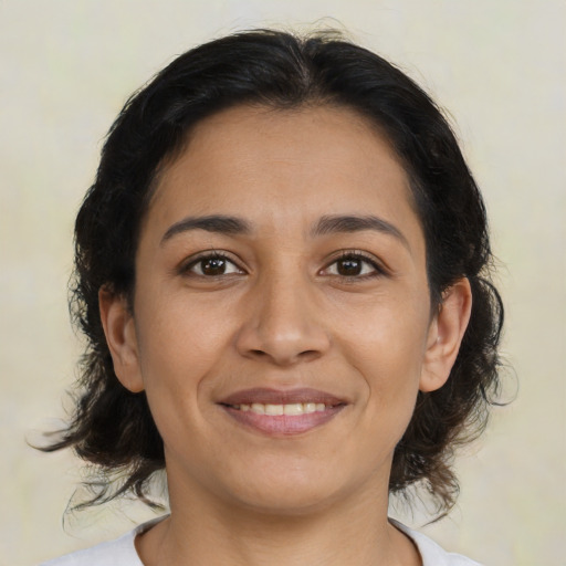 Joyful latino young-adult female with medium  brown hair and brown eyes