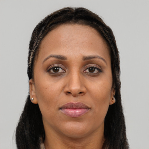 Joyful black adult female with long  brown hair and brown eyes