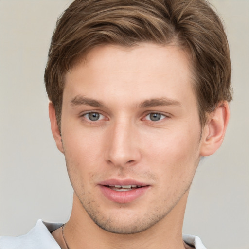 Joyful white young-adult male with short  brown hair and grey eyes