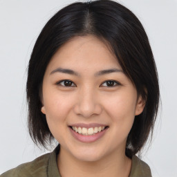 Joyful asian young-adult female with medium  brown hair and brown eyes