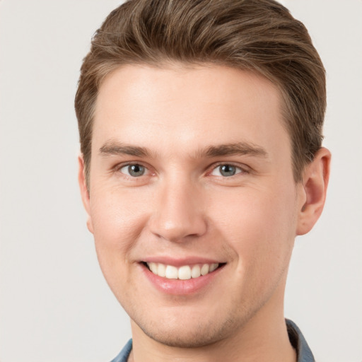 Joyful white young-adult male with short  brown hair and grey eyes