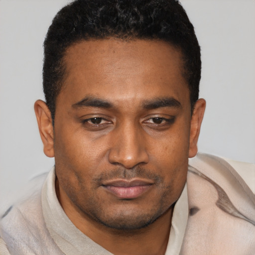 Joyful black young-adult male with short  brown hair and brown eyes