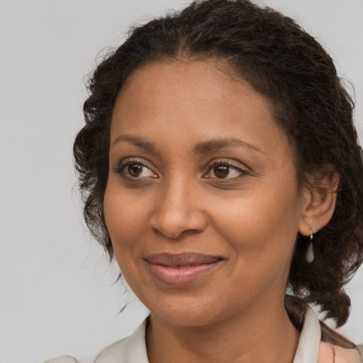 Joyful black adult female with medium  brown hair and brown eyes