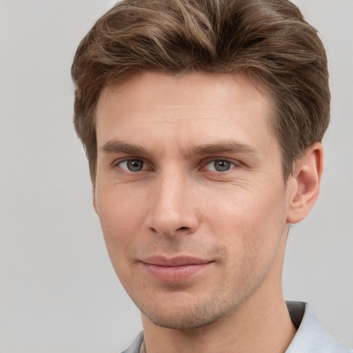 Joyful white young-adult male with short  brown hair and grey eyes