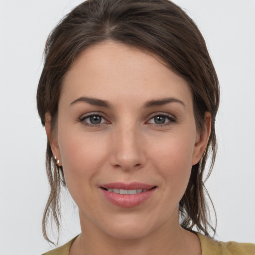 Joyful white young-adult female with medium  brown hair and grey eyes