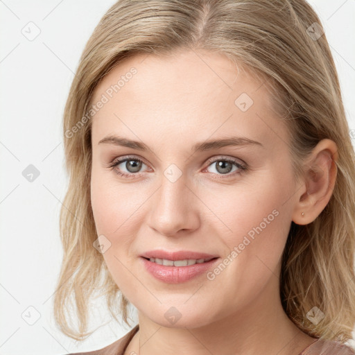 Joyful white young-adult female with long  brown hair and blue eyes