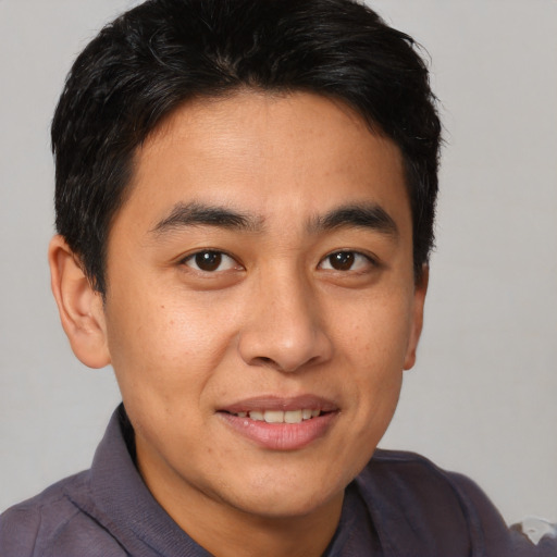 Joyful asian young-adult male with short  brown hair and brown eyes
