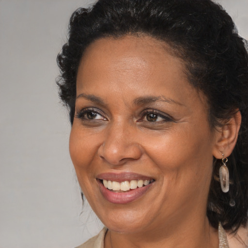Joyful black adult female with medium  brown hair and brown eyes