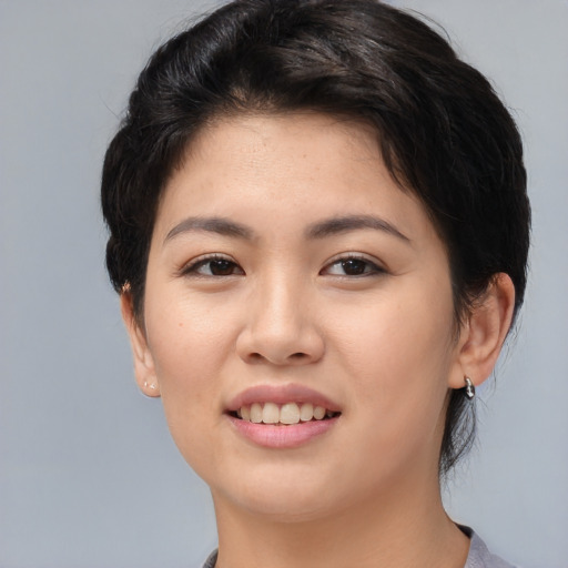 Joyful asian young-adult female with medium  brown hair and brown eyes
