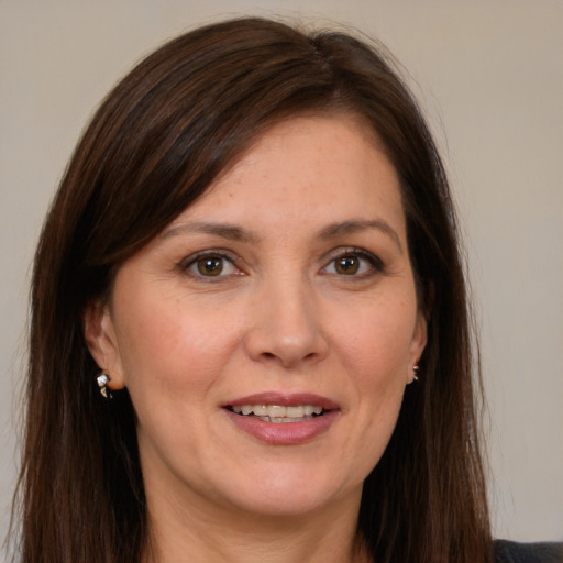 Joyful white adult female with long  brown hair and grey eyes