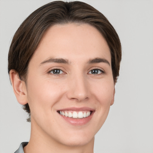 Joyful white young-adult female with short  brown hair and brown eyes