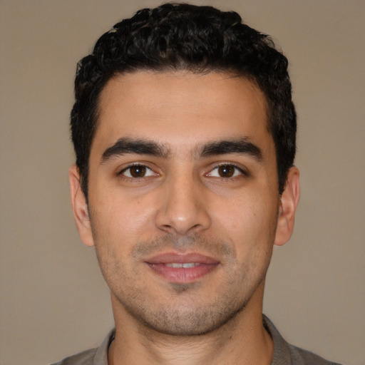 Joyful white young-adult male with short  black hair and brown eyes
