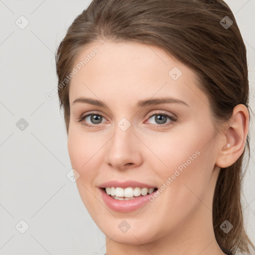 Joyful white young-adult female with long  brown hair and grey eyes